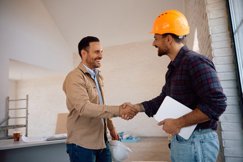 Cliente soddisfatto stringe la mano al lavoratore dell’impresa di ristrutturazione