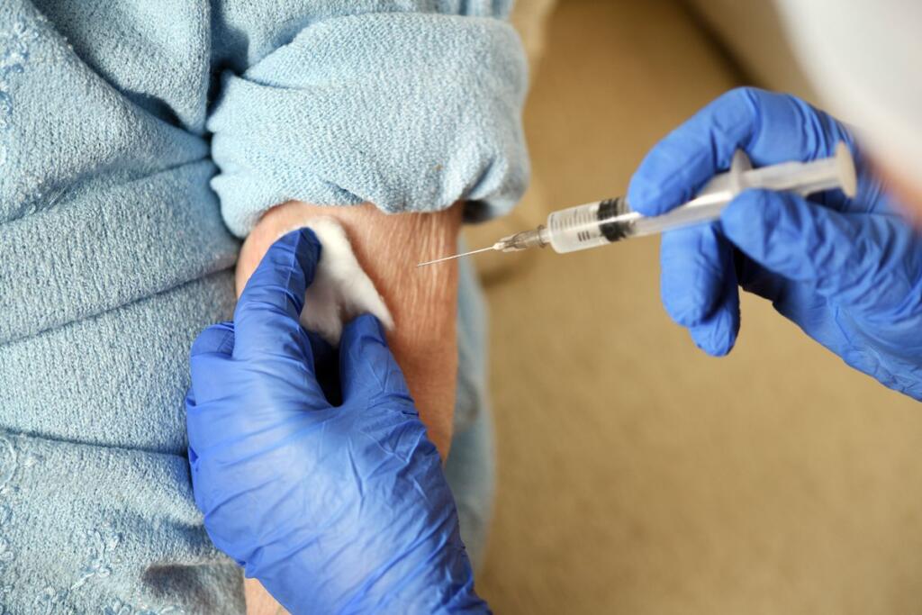 Anziana si sottopone al vaccino anti-COVID-19