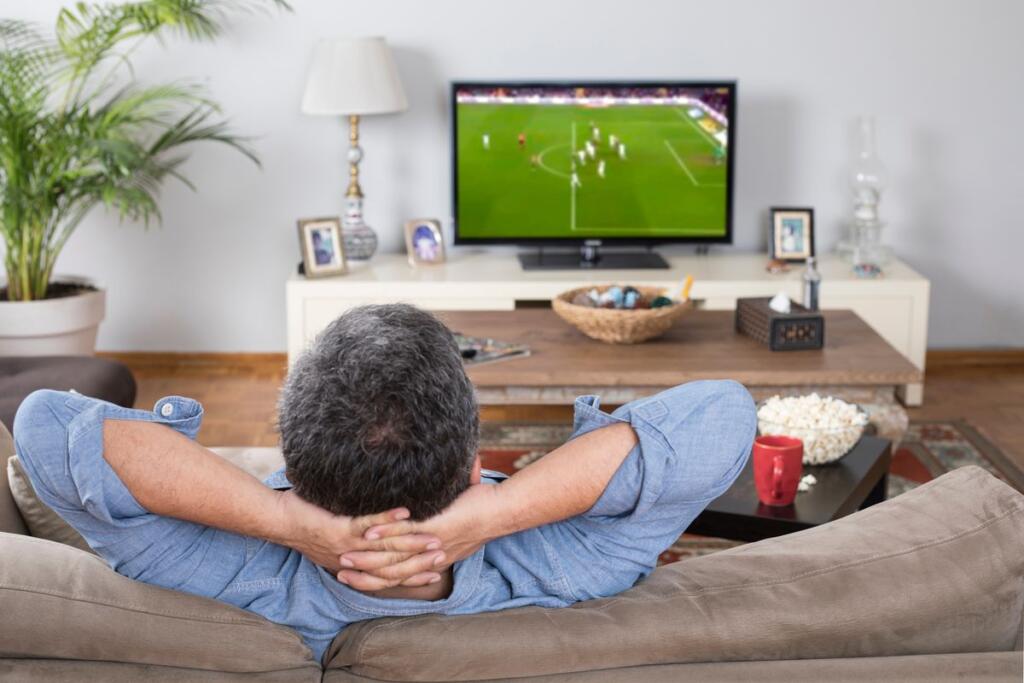 Un uomo guarda una partita in tv