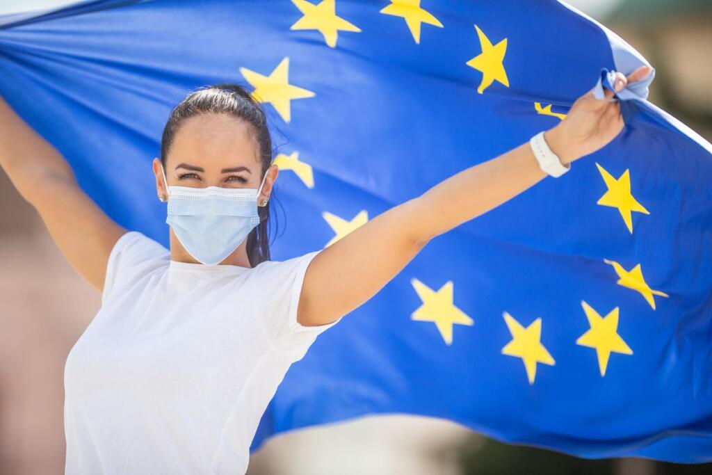Ragazza con mascherina e bandiera UE