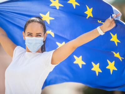 Ragazza con mascherina e bandiera UE