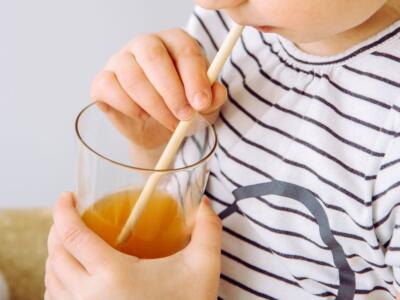 Un bimbo beve con la cannuccia biodegradabile
