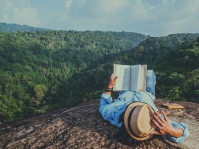 Uomo legge un libro in montagna