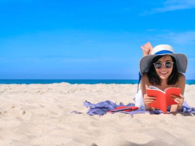 Ragazza legge libro in spiaggia