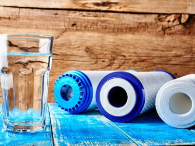 Un bicchiere d'acqua e i filtri per depurarla