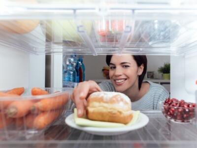 Ragazza che prende il cibo dal frigo