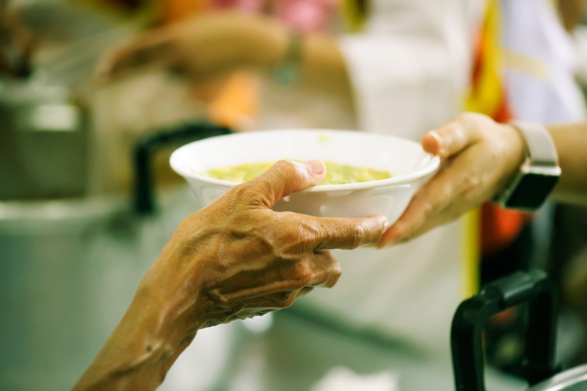 Una persona in difficoltà riceve un pasto caldo