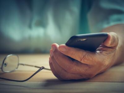 Un anziano usa uno smartphone