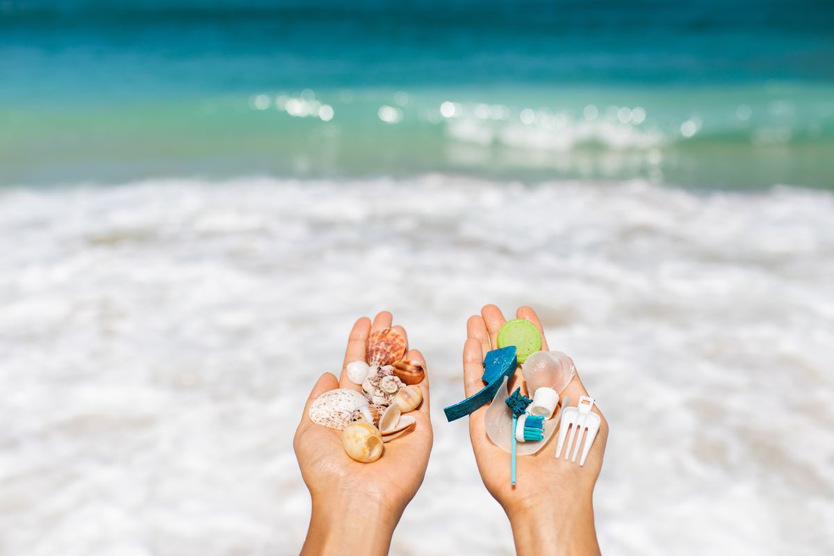 Un bambino raccoglie conchiglie e plastica dal mare