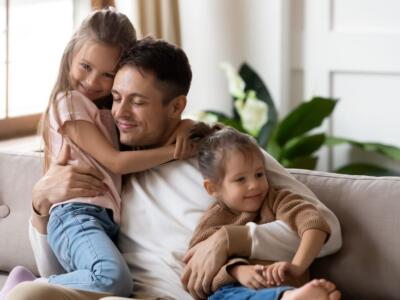 padre e figlie casa divano abbracci