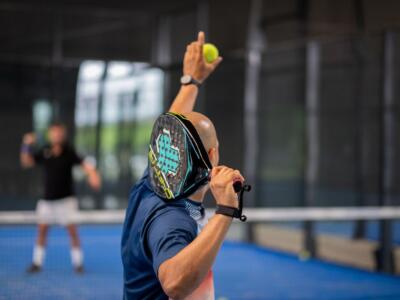 Un giocatore di padel in battuta