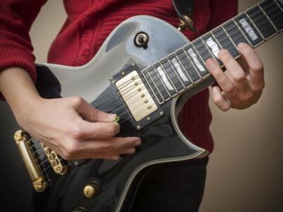 Una donna suona la chitarra elettrica