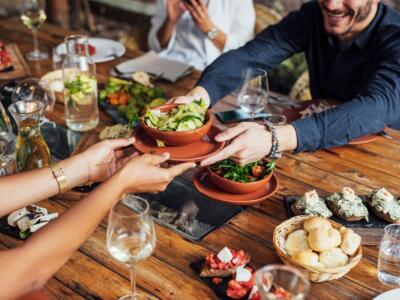 Un gruppo di persone mangia insieme al ristorante