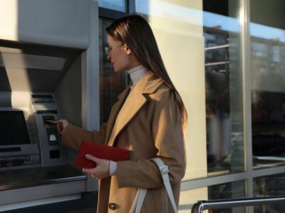 Una donna preleva al Bancomat con la carta