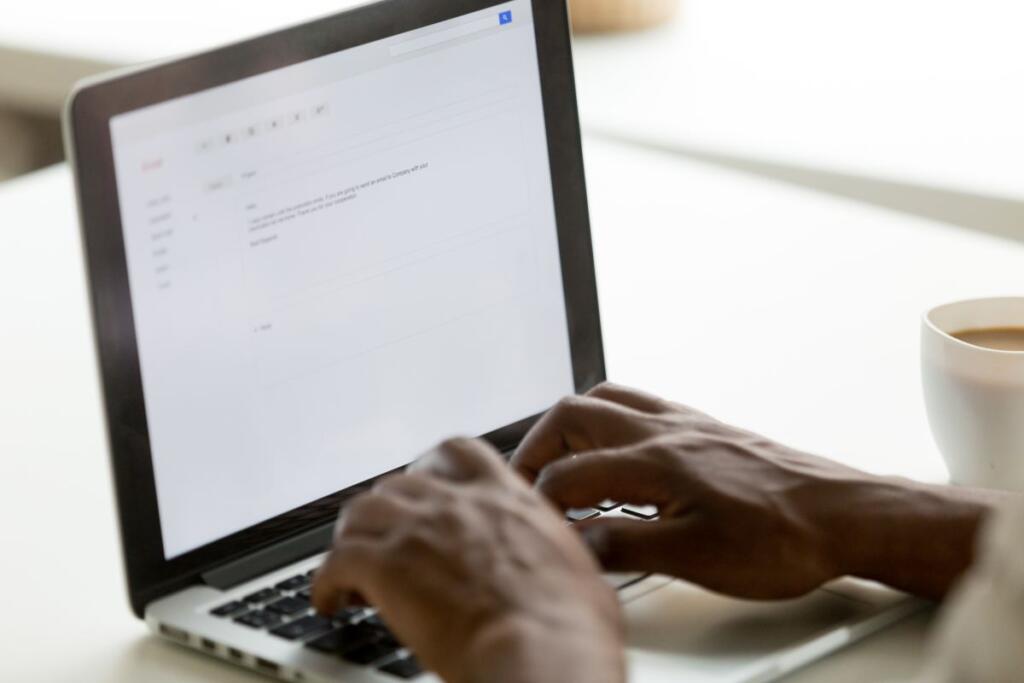 Un uomo al portatile scrive una mail usando Gmail