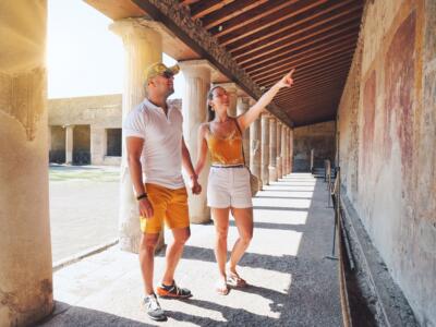 Una coppia di turisti ammira un affresco nel Parco Archeologico di Pompei