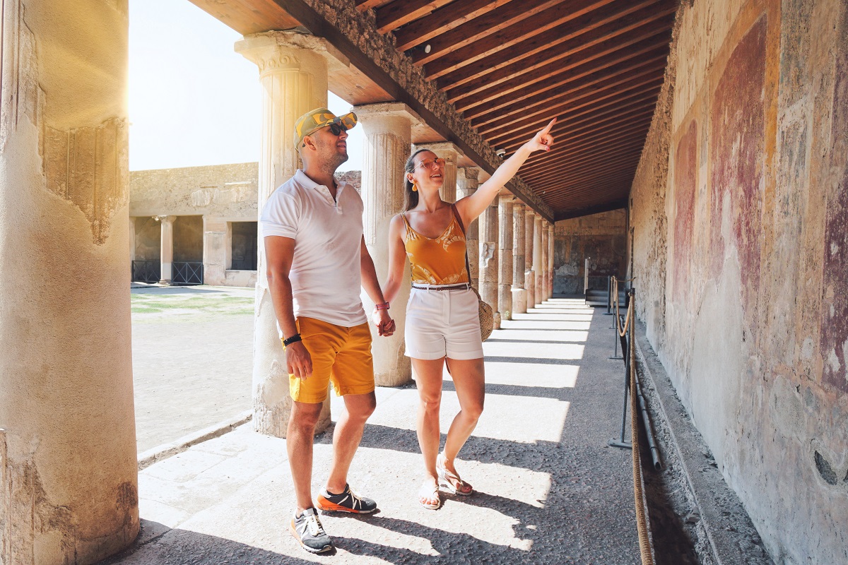 Una coppia di turisti ammira un affresco nel Parco Archeologico di Pompei