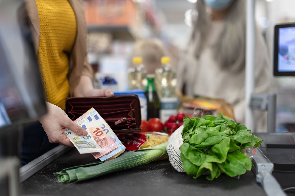 Una donna paga la spesa al supermercato