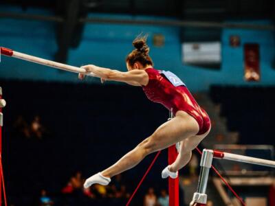 Una ginnasta a gambe divaricate alla sbarra