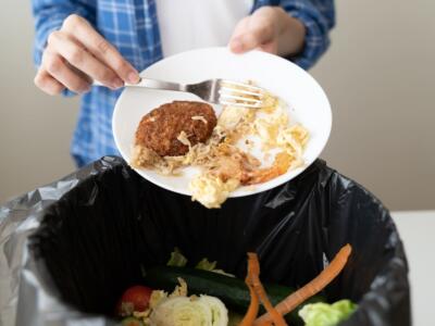 Un uomo spreca cibo buttando i resti di un pasto