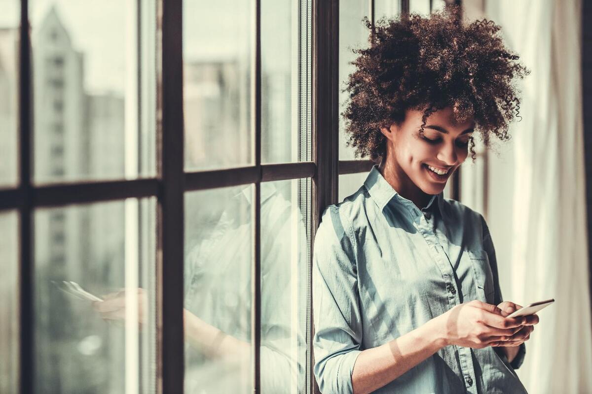 Ragazza che sorride e guarda il telefono