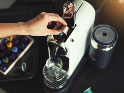 Una donna inserisce una capsula nella macchina del caffè