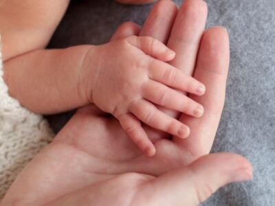 Una mamma tiene la mano del suo neonato