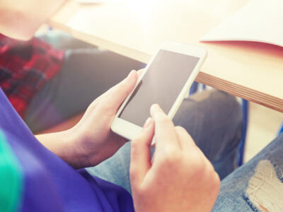 Un ragazzo in classe a scuola con lo smartphone