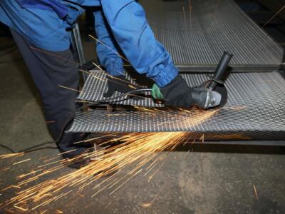 Un lavoratore detenuto taglia una rete di metallo