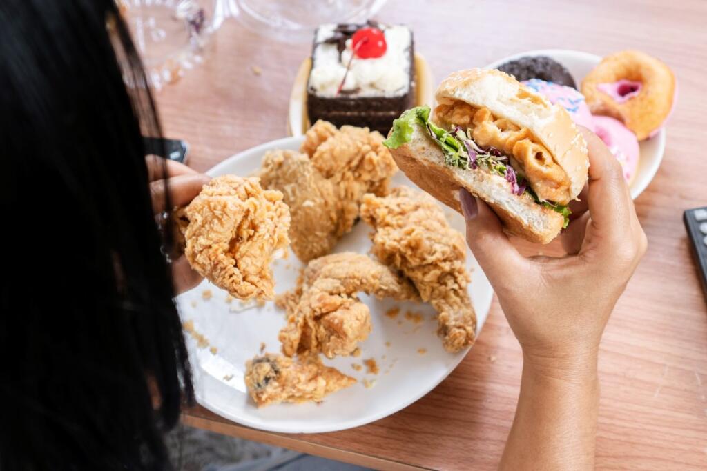 Una ragazza mangia junk food