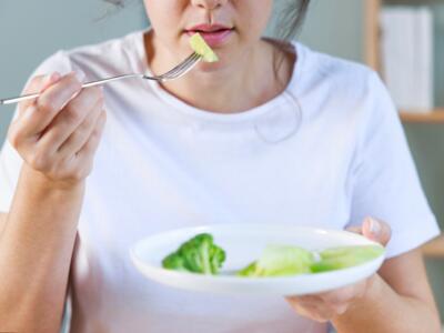 Una ragazza mangia verdure e insalata