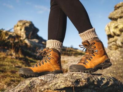 Una donna cammina in montagna con scarpe da trekking