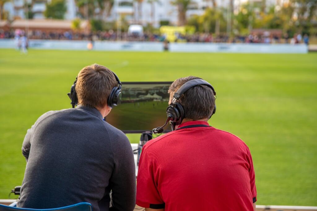 Due telecronisti sul campo per una partita di calcio