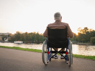 Un anziano disabile in riva a un fiume