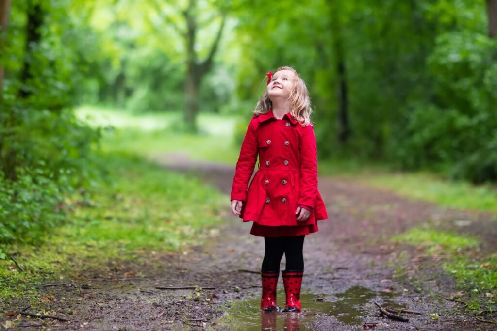 Bambina con stivali e giacca da pioggia