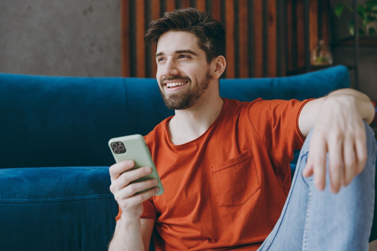 Ragazzo sorridente guarda smartphone