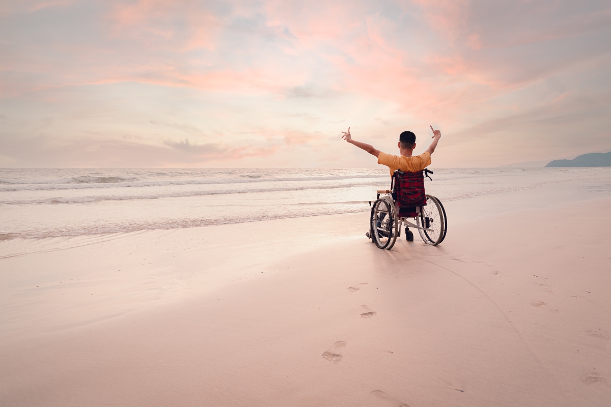 Un ragazzino disabile al mare in carrozzina