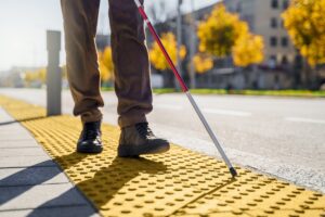 Una persona non vedente cammina con il suo bastone