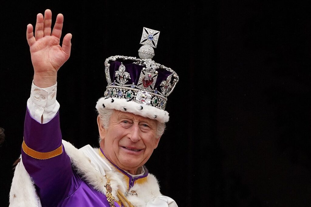 Re Carlo III, con la Corona Imperiale, saluta dal balcone di Buckingham Palace.