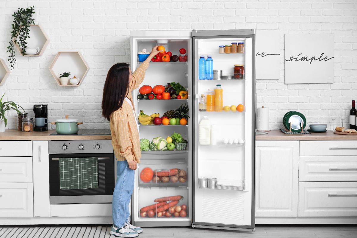 Ragazza apre il frigo in cucina