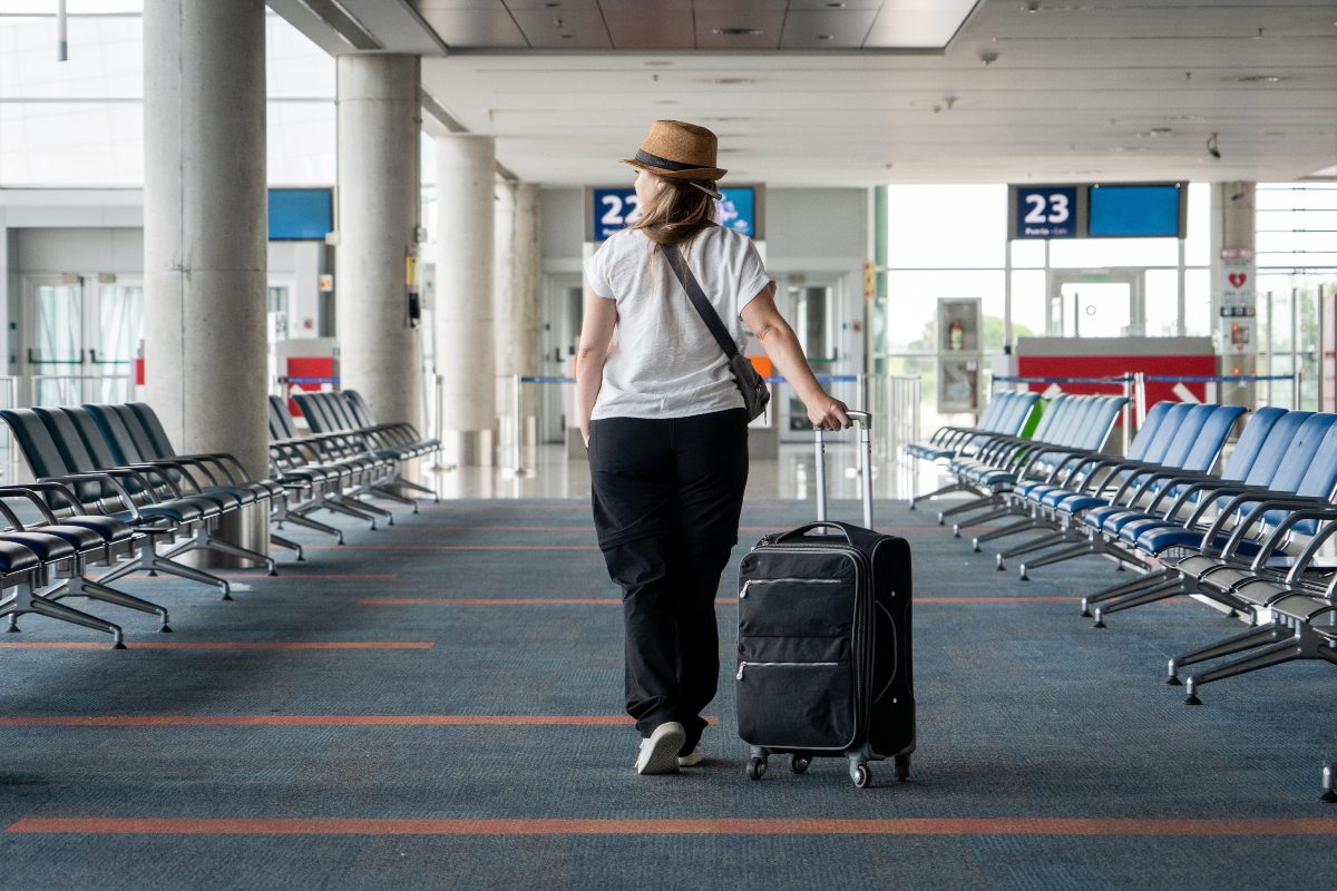 Una viaggiatrice con il trolley in aeroporto