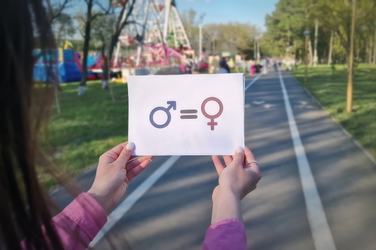 Una donna regge un cartello per la parità di genere
