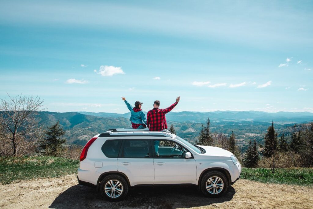 Coppia in montagna con SUV parcheggiato