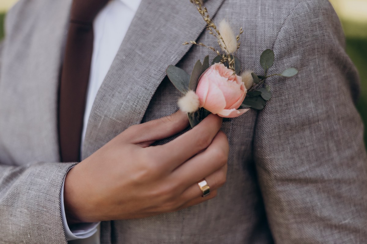 Look elegante maschile con giacca, cravatta e fiore