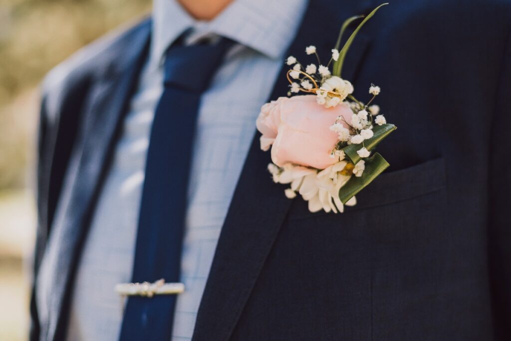 Uomo in abito con cravatta e boutonnière