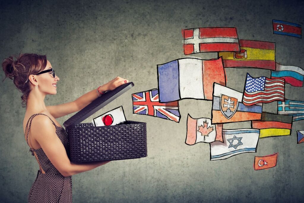 Ragazza che apre una scatola da cui fuoriescono bandiere di vari Paesi.