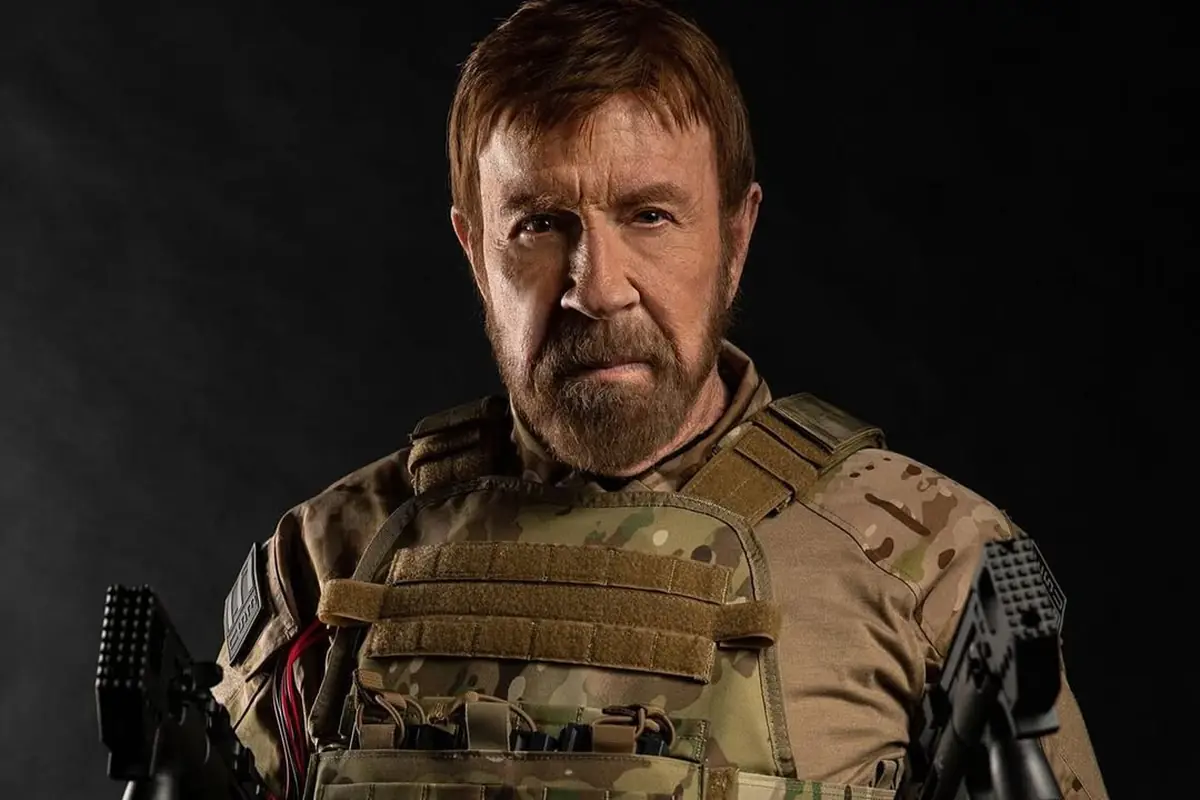 Chuck Norris in primo piano con abbigliamento militare e sguardo intenso